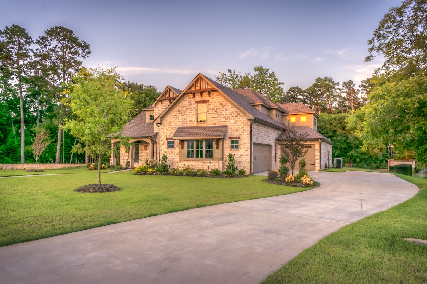Beautiful stone house at dusk with green lawn